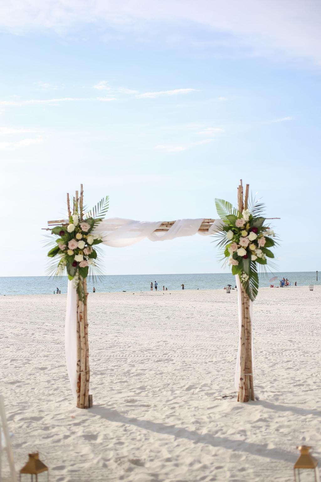 Clearwater Beach Waterfront Wedding Ceremony Decor, Birchwood Arch with White Draping, Blush Pink, White and Green Palm Tree Leaves | Tampa Bay Wedding Photographer Lifelong Photography Studios