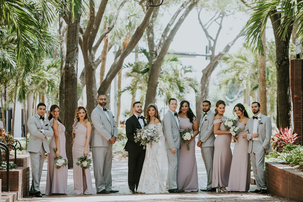 Elegant Outdoor Bride, Groom and Bridal Party Wedding Portrait, Bridesmaids in Lavender Dresses, Groomsmen in Grey Tuxedos, Bride in Lace and Illusion Long Sleeve Scoop Neckline and Groom in Black Tuxedo | Tampa Bay Wedding Photographer Brandi Image Photography