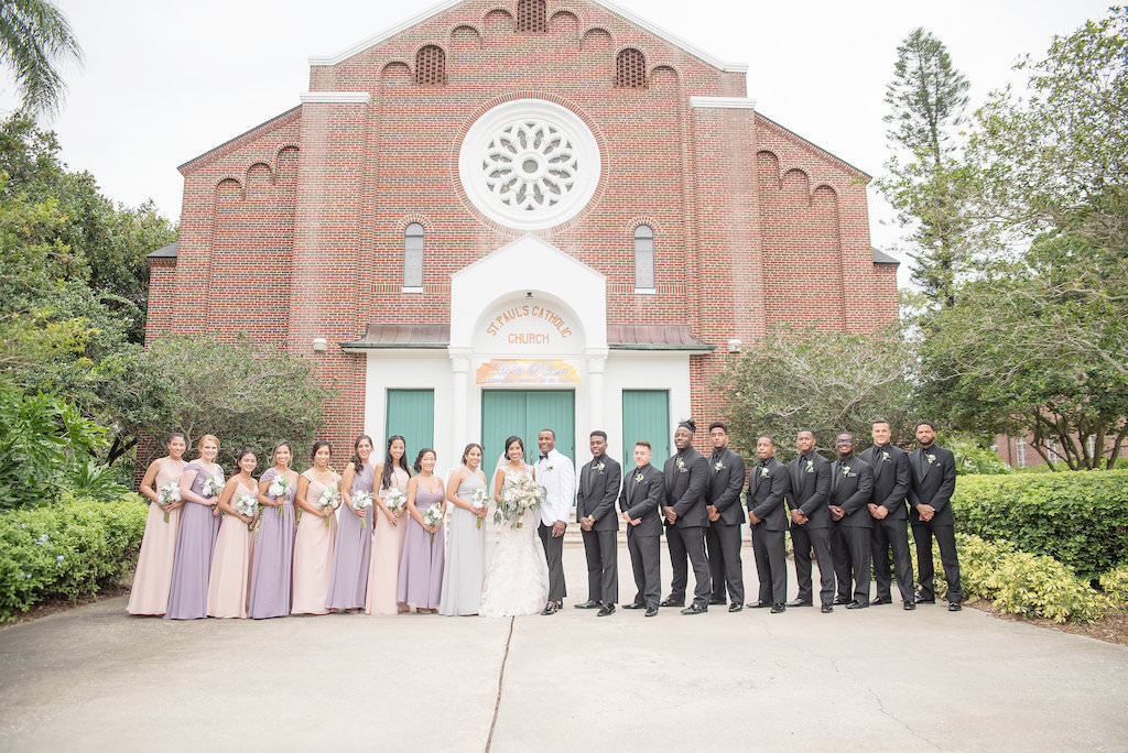 Outdoor Florida Bride, Groom and Bridal Party Wedding Portrait, Bridesmaids in Mismatched Blush Pink and Purple Long Dresses, Groomsmen in Black Tuxedos | Tampa Bay Wedding Photographer Kristen Marie Photography | St. Pete Wedding Venue St. Paul's Catholic Church