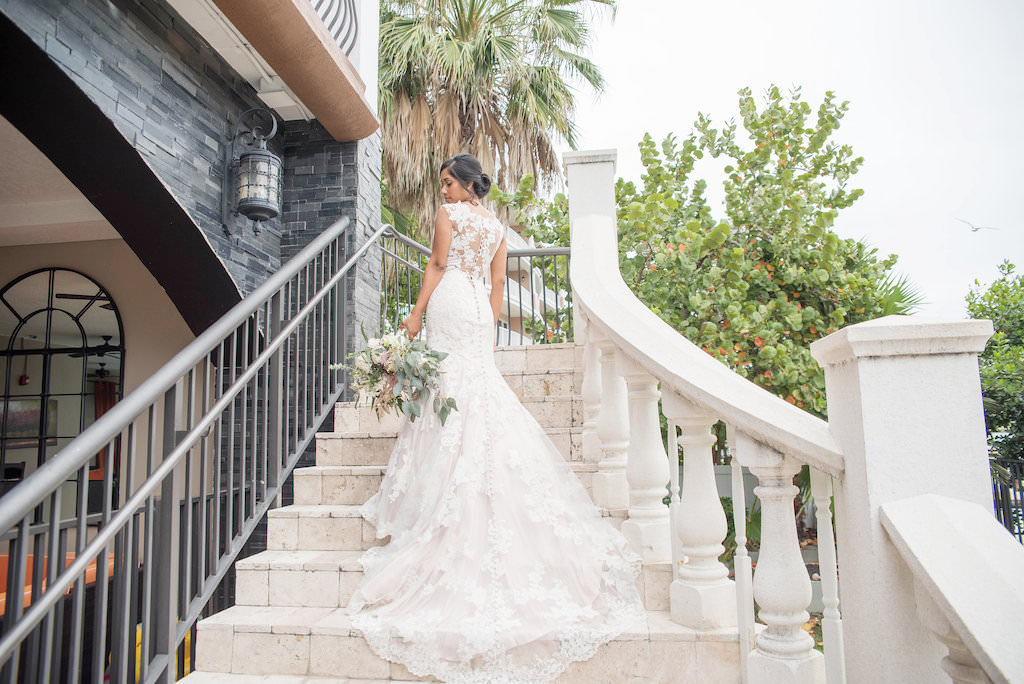 Florida Bride Outdoor Wedding Portrait on Staircase in Fitted Lace and Illusion Allure Cap Sleeve Wedding Dress with Organic Garden Inspired Floral Bouquet | Tampa Bay Wedding Photographer Kristen Marie Photography