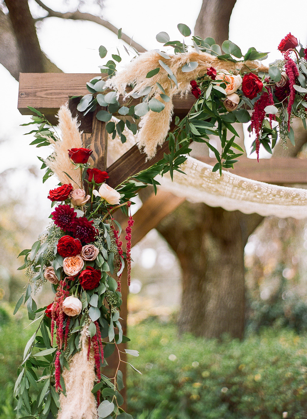Boho Chic Inspired Outdoor Lakeland Florida Wedding Ceremony Decor, Wooden Arch with Red, Ivory, Pink and Greenery Organic Floral Decor and Ceremony Table