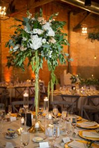 Industrial Chic Wedding Reception Decor, Tall Gold Stand withWhite and Greenery Floral Centerpiece, Floating Candlesticks | Tampa Bay Wedding Photographer Andi Diamond Photography | Tampa Industrial Unique Wedding Venue Armature Works
