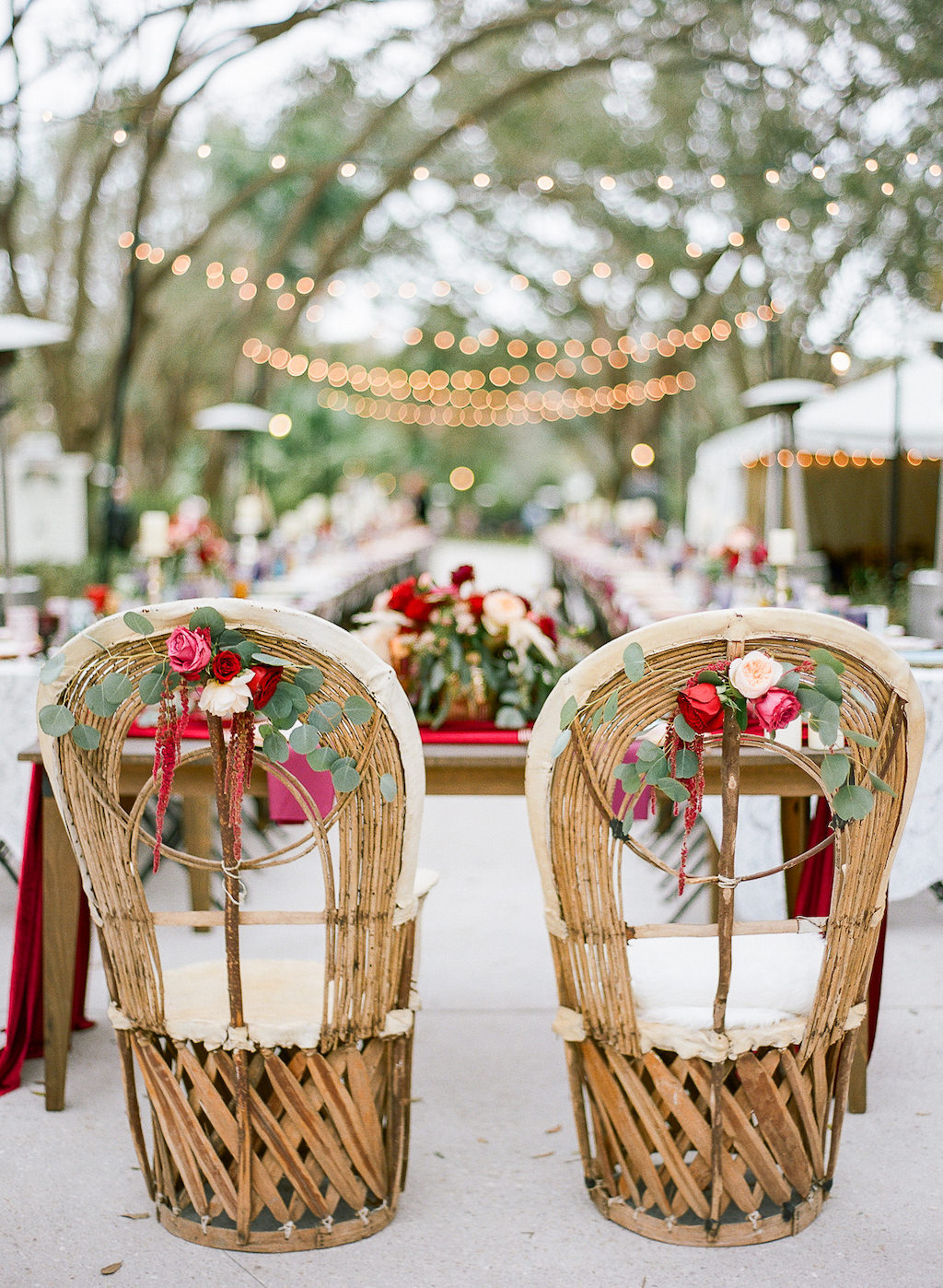 Boho Chic Vintage Inspired Outdoor Lakeland Florida Wedding Reception Decor, Wicker Chairs with Red, Pink, White and Greenery Florals on Wicker Chairs for Sweetheart Table