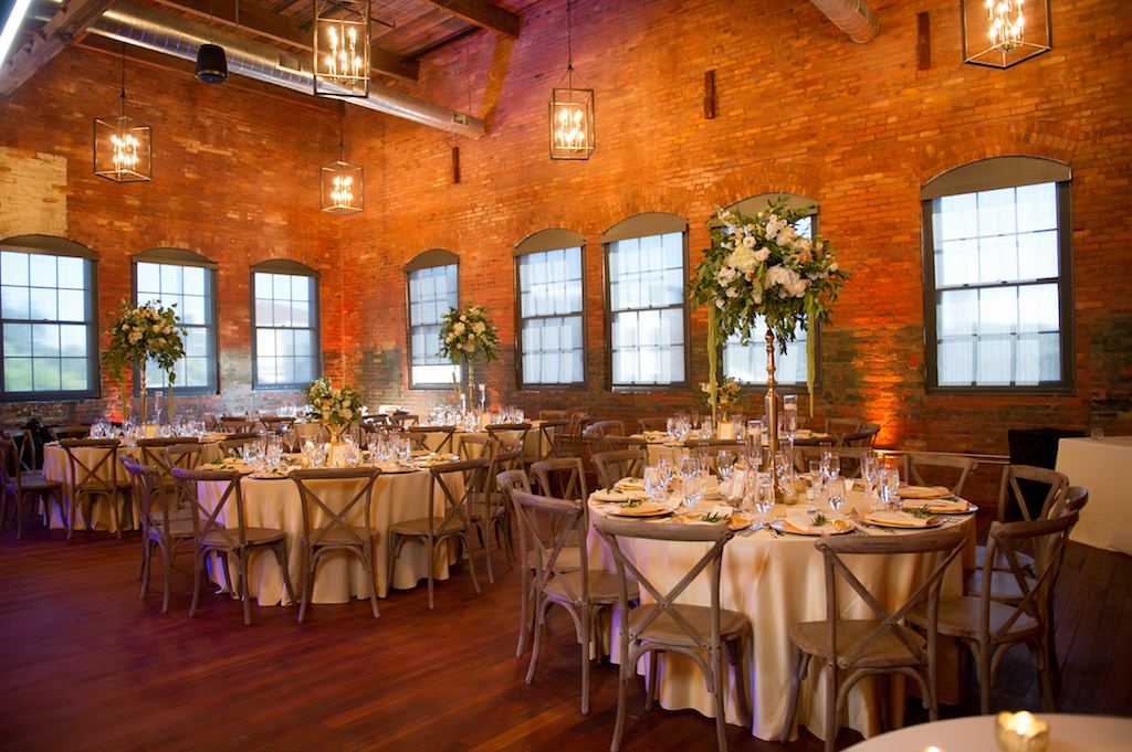 Industrial Chic Wedding Reception Decor, Round Tables with White Tablecloths, Wooden Chiavari Chairs, High Low Floral Centerpieces | Tampa Bay Wedding Photographer Andi Diamond Photography | Tampa Industrial Unique Wedding Venue Armature Works