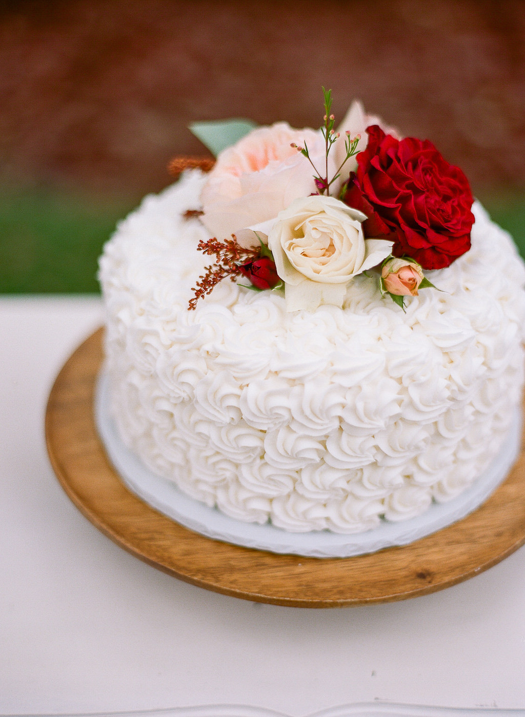 White Buttercream Floral Designs Wedding Cake Topped with Real Red, Blush Pink and Ivory Florals