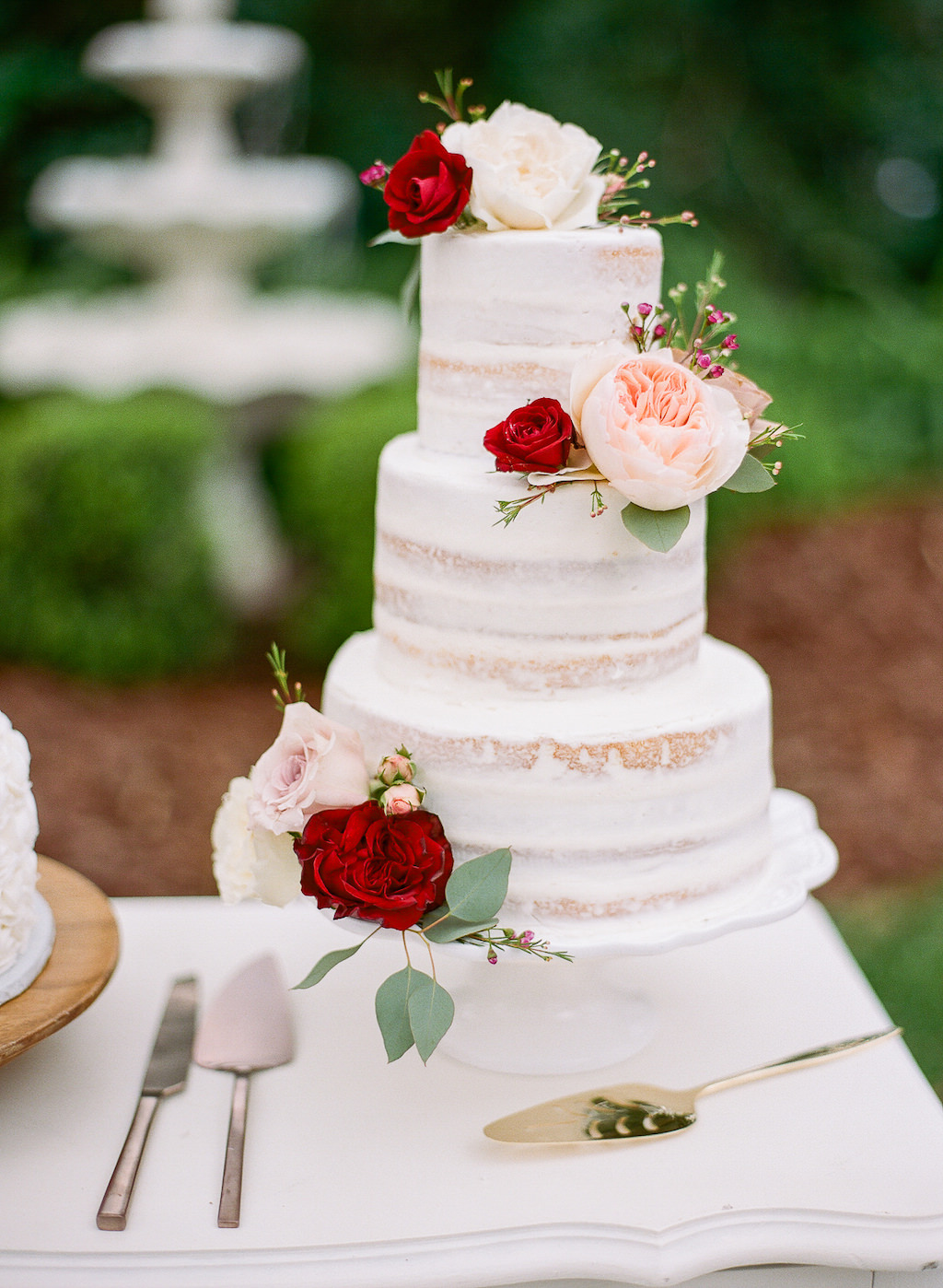 Three Tier White Semi Naked Wedding Caked with Real Blush Pink and Red Flowers