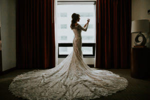Bride Getting Ready Wedding Portrait, Bride in Lace and Illusion Long Sleeve and Elegant Train Wedding Dress | Tampa Bay Wedding Photographer Brandi Image Photography | Downtown Tampa Wedding Venue Hilton Tampa Downtown