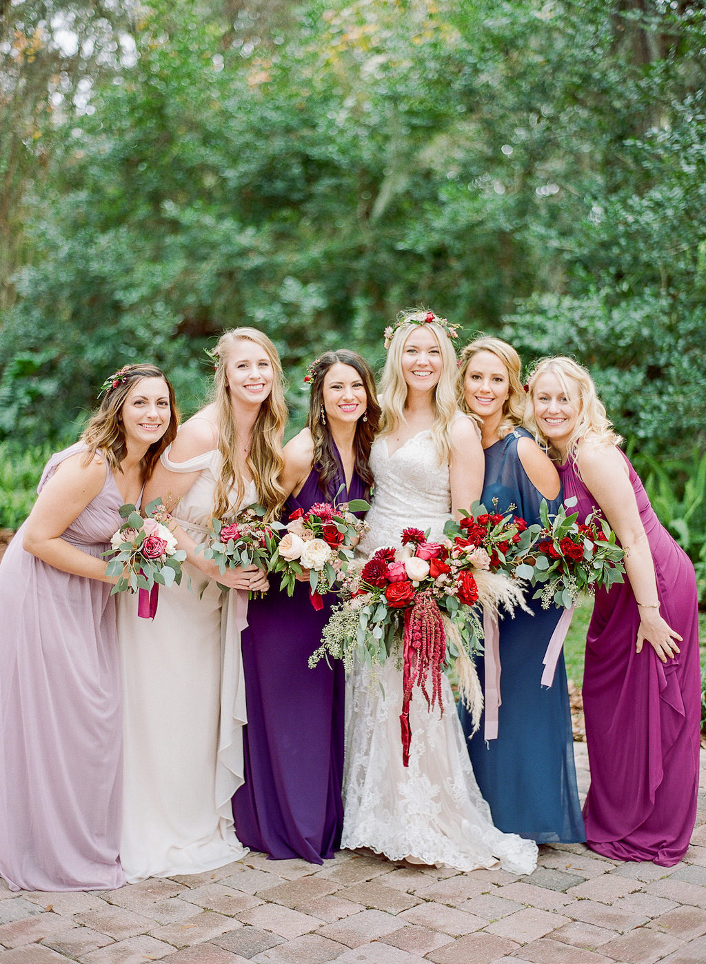 Outdoor Bride and Bridal Party Wedding Portrait, Bridesmaids in Mismatched Dresses, Bride in Fitted Lace Wedding Dress with Red, Pink, Ivory and Greenery Floral Bouquet | Tampa Bay Bridal Shop Nikkis Glitz and Glam Bridal Boutique