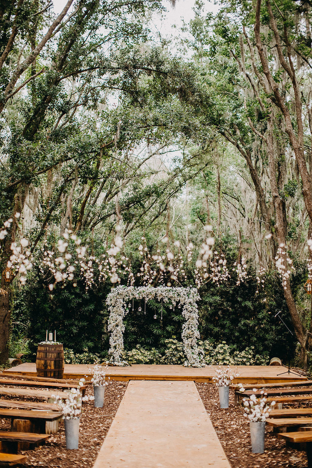 Elegant Outdoor Rustic Wedding Ceremony Decor, White and Greenery Floral Arch with Hanging Glass Bulbs | Lakeland Rustic Wedding Venue The Prairie Glenn Barn at Gable Oaks Ranch