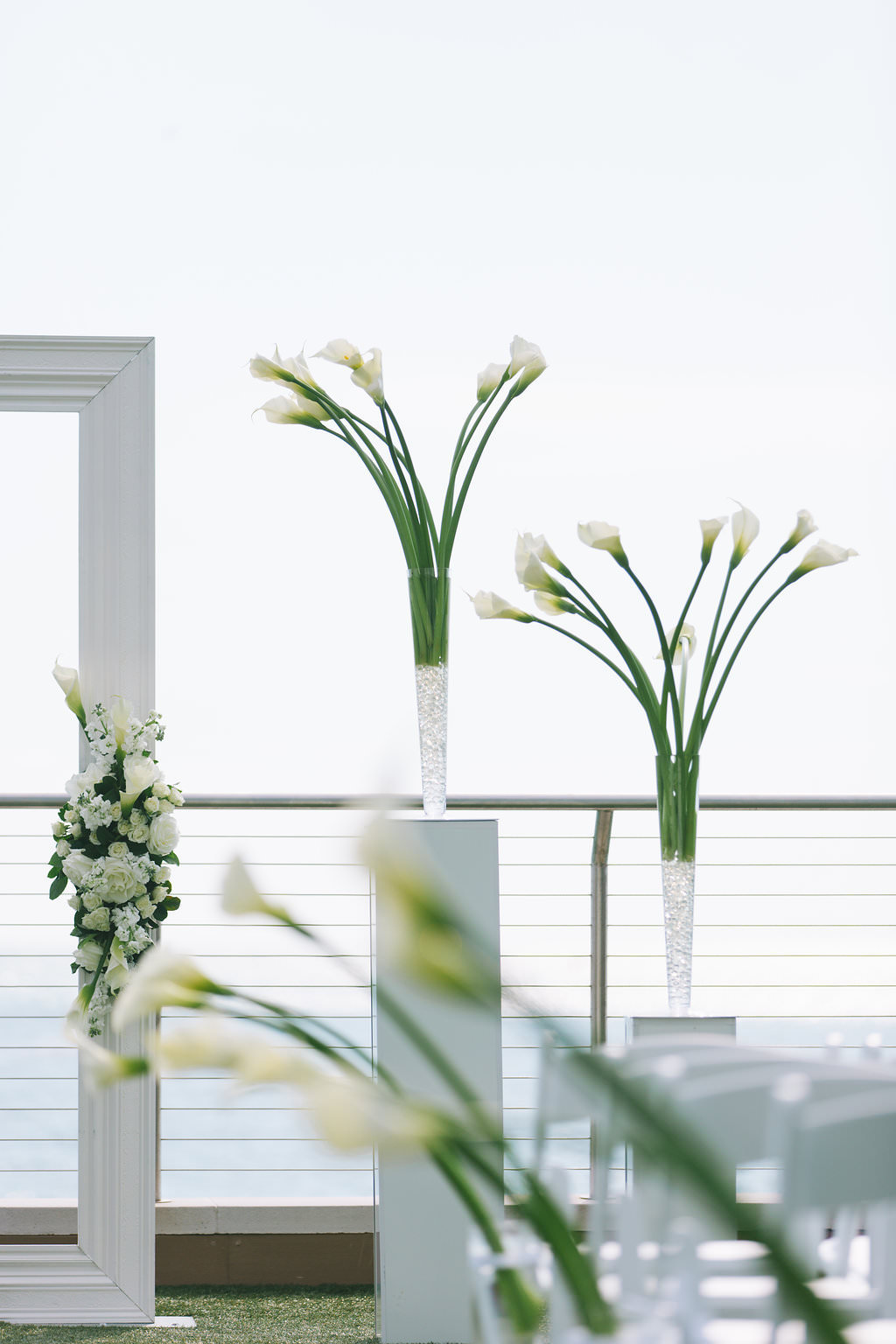 Modern Elegant Waterfront and Lawn Wedding Ceremony Decor, White Frame with Greenery and White Floral Arrangements, Tall White Pedestals with White Tulips | Tampa Bay Wedding Photographer Kera Photography | Clearwater Beach Wedding Venue Opal Sands Resort