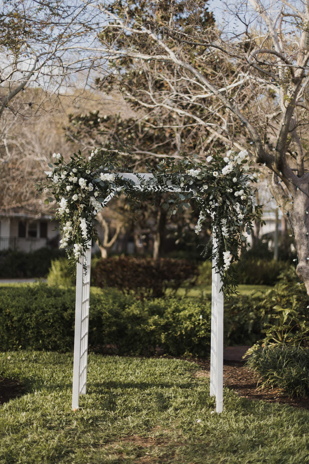 Garden Inspired Wedding Ceremony Decor, White Wooden Arch with Greenery and White Florals | St. Petersburg Woman’s Club