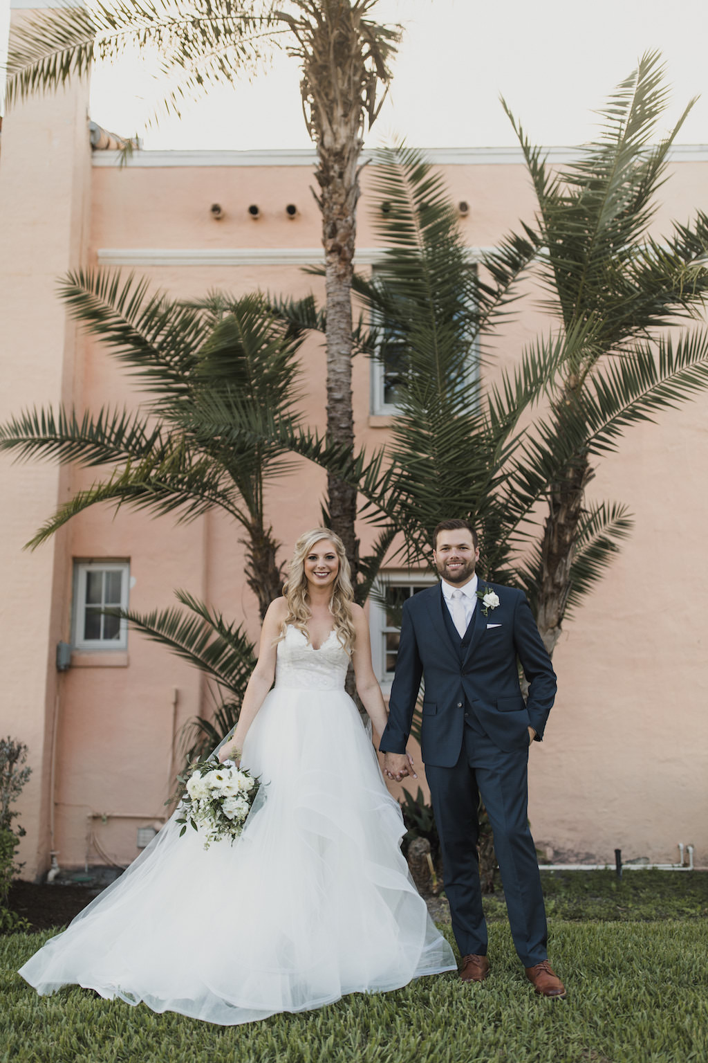 Outdoor Florida Bride and Groom Wedding Portrait, Bride in Strapless Hayley Paige Chantelle Gown, Ivory Tulle Skirt Ball Gown with Lace Corset Bodice, White and Greenery Floral Bouquet, Groom in Navy Blue Suit | Tampa Bay Wedding Hair and Makeup Artist Michele Renee the Studio