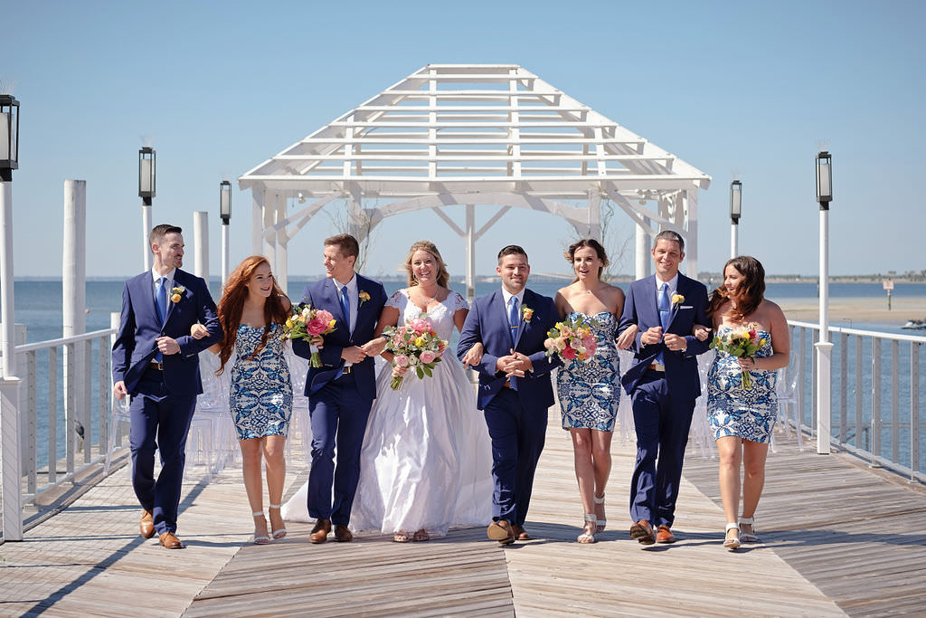 Florida Bride and Groom with Bridal Party Wedding Portrait on Waterfront Private Dock, Bridesmaids in Short White and Blue with Design Dresses, Groomsmen in Blue Suits with Brown Wing Tipped Dress Shoes, Bride in White Lace and Satin Sweetheart Neckline and Capsleeve Ballgown Wedding Dress | Waterfront Island Inspired Wedding Venue The Godfrey Hotel and Cabanas Tampa | Tampa Bay Wedding Photographer Marc Edwards Photographs