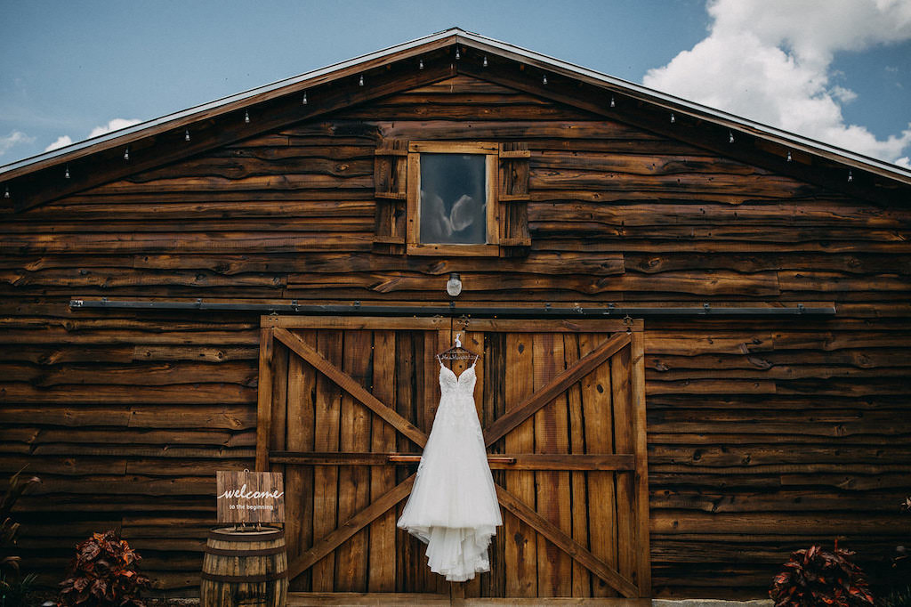 Rustic Inspired Wedding, Spaghetti Strap Lace A Line Wedding Dress Hanging Outside Barn | Lakeland Rustic Barn Wedding Venue The Prairie Glenn Barn at Gable Oaks Ranch