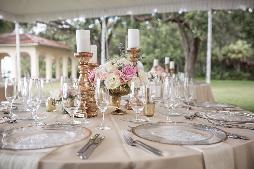 Florida Outdoor Tent Wedding Reception Decor, Round Tables with Champagne Tablecloth, Gold Rimmed and Clear Glass Chargers, Low Gold Vase with Blush Pink and White Floral Bouquet, Tall Gold Candlesticks | Tampa Bay Wedding Photographer Cat Pennenga Photography | Wedding Planner NK Productions | Sarasota Wedding Venue Powel Crosley Estate