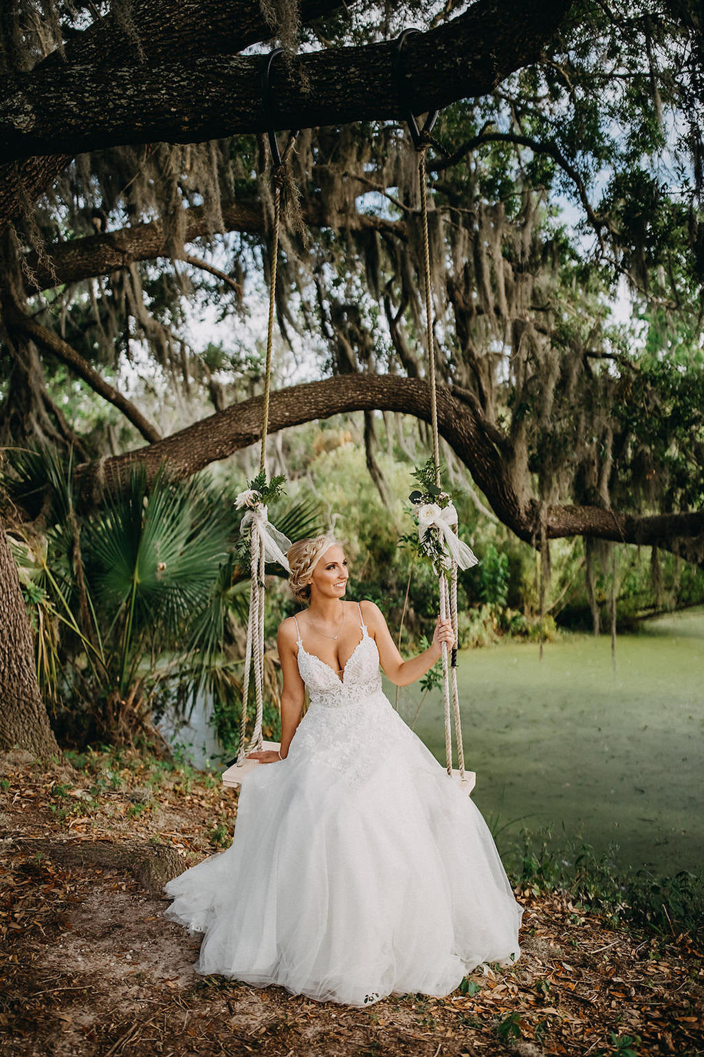Florida Outdoor Rustic Inspired Wedding Portrait on Swing, Bride in Spaghetti Strap V Neck Lace A Line Wedding Dress with Braided Updo | Lakeland Rustic Wedding Venue The Prairie Glenn Barn at Gable Oaks Ranch