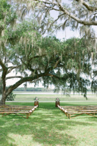 Rustic Florida Outdoor Wedding Ceremony Decor, Wooden Benches, Wooden Barrels with Floral Arrangements | Inverness Rustic Wedding Venue Lakeside Ranch
