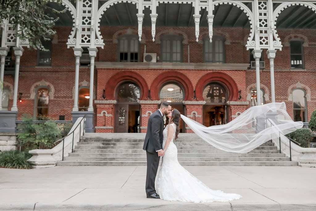 Florida Bride and Groom Outside University of Tampa Wedding Portrait with Veil Blowing in Wind | Tampa Bay Wedding Photographer Lifelong Photography Studio