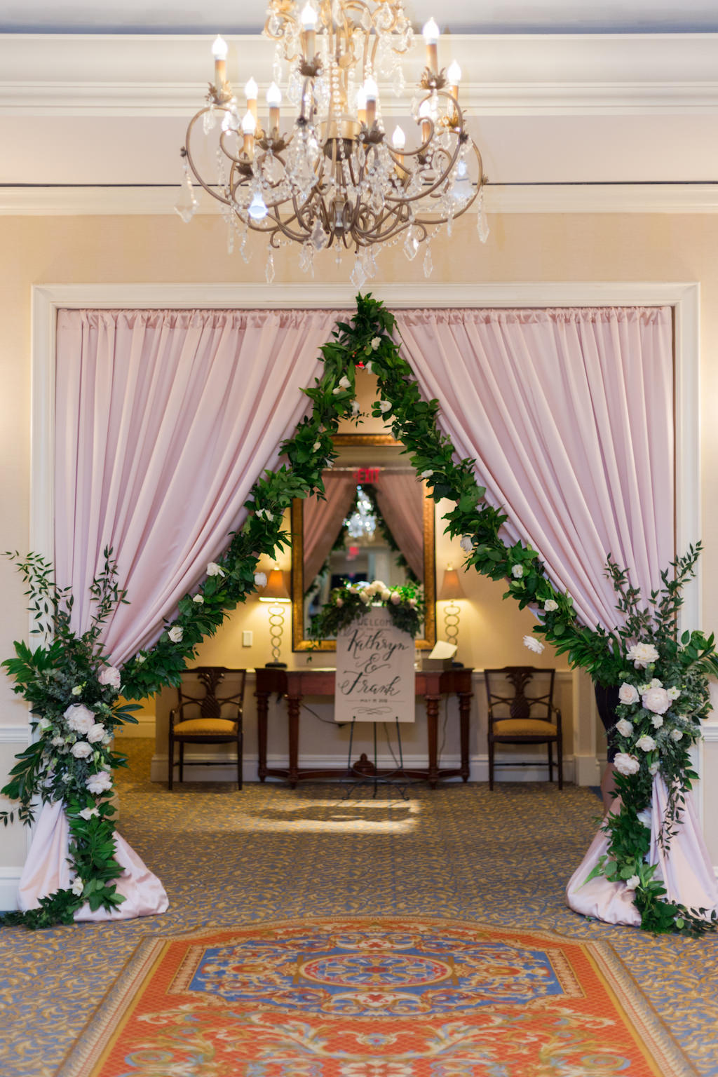 Blush Pink Drapery, Greenery Garland with Ivory Florals Curtain Entrance for Wedding Reception | Tampa Bay Linens Rental Company Over the Top Linens