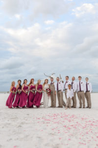 Florida Beachfront Bride, Groom and Bridal Party Wedding Portrait, Bridesmaids in Pinkish Purple Magenta Long Mismatched Style Dresses, Bride in Long Fitted Lace Halter Strap BHLDN Wedding Dress, Groom and Groomsmen in Khaki Suit Pants, White Shirts and Plum Purple Ties | Tampa Bay Wedding Photographer Lifelong Photography Studios | Clearwater Beach Hotel Wedding Venue Hilton Clearwater Beach