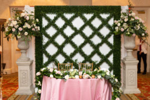 Wedding Reception Decor, Greenery and White Backdrop Wall, Sweetheart Table with Pink Tablecloth, Greenery Garland with Blush Pink and Ivory Roses, Pedestals with Ivory, Blush Pink, Greenery Floral Bouquets | Tampa Bay Wedding Renal Company Over the Top Rental Linens, A Chair Affair