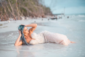 Beachfront Wedding Mermaid Inspired Styled Shoot, Bride in Nude Sweetheart Neckline Pearl Embellished Fitted Wedding Dress Laying In Sand | Tampa Bay Wedding Venue Fort DeSoto Park