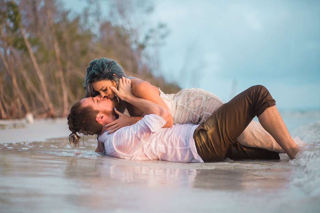 Beachfront Wedding Mermaid Inspired Styled Shoot, Bride in Nude Sweetheart Neckline Pearl Embellished Fitted Wedding Dress Laying In Sand | Tampa Bay Wedding Venue Fort DeSoto Park