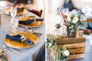 Vintage Rustic Whimsical Inspired Wedding Reception Decor, Round Table with Dusty Blue Tablecloth, Gold Chargers, Navy Blue Linens, Wooden Pallet Box with Candelsticks, Vases with Greenery and White Floral Centerpieces | Tampa Bay Wedding Planner Love Lee Lane | Rentals A Chair Affair