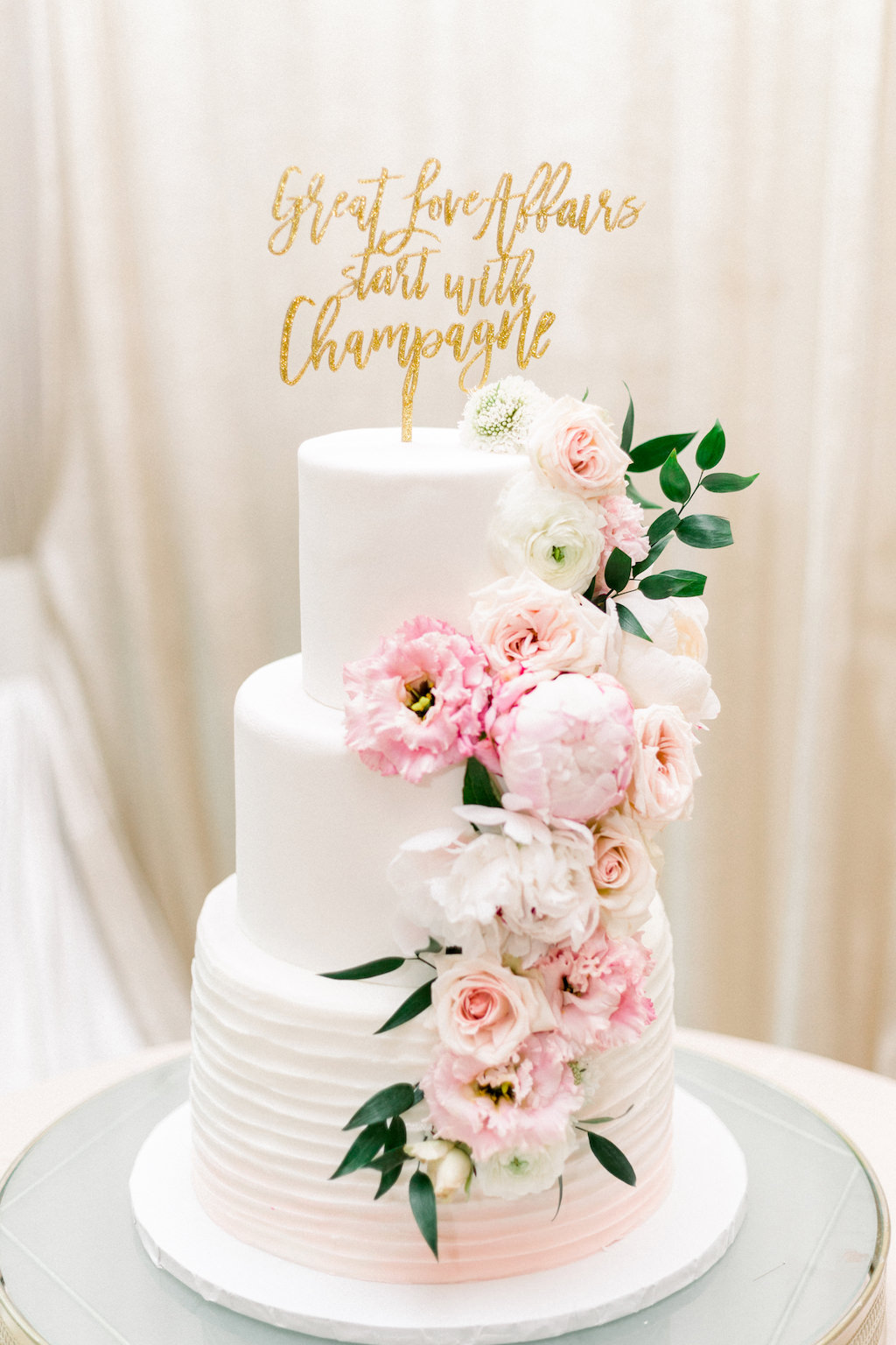 Three Tier White and Blush Pink Ombre Wedding Cake with Cascading Blush Pink, Ivory and Greenery Florals and Gold Laser Cur Cake Topper