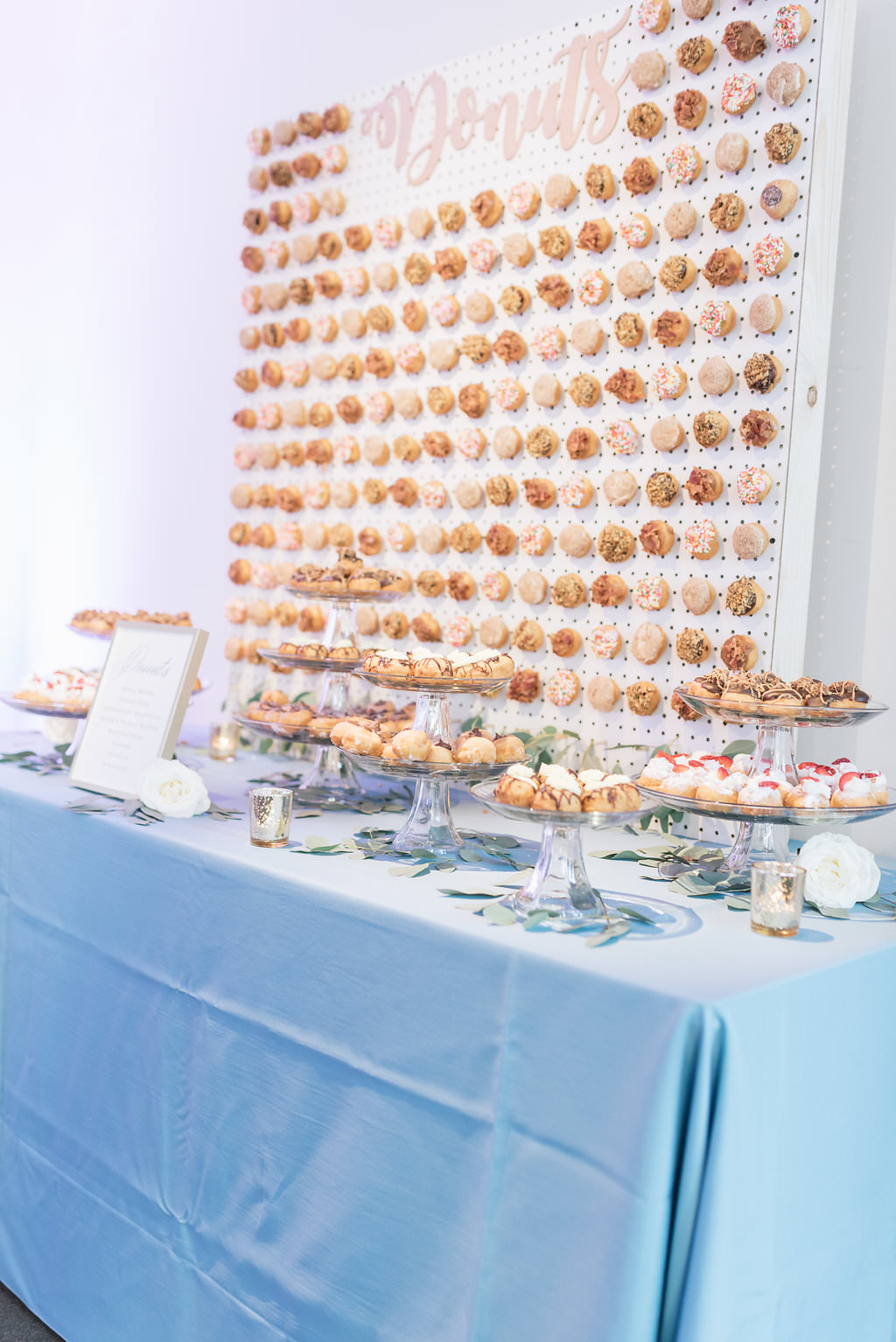 Classic Wedding Reception Decor, Long Dessert Table with Dusty Blue Tablecloth, Donut Wall and Dessert Platters on Glass Stands