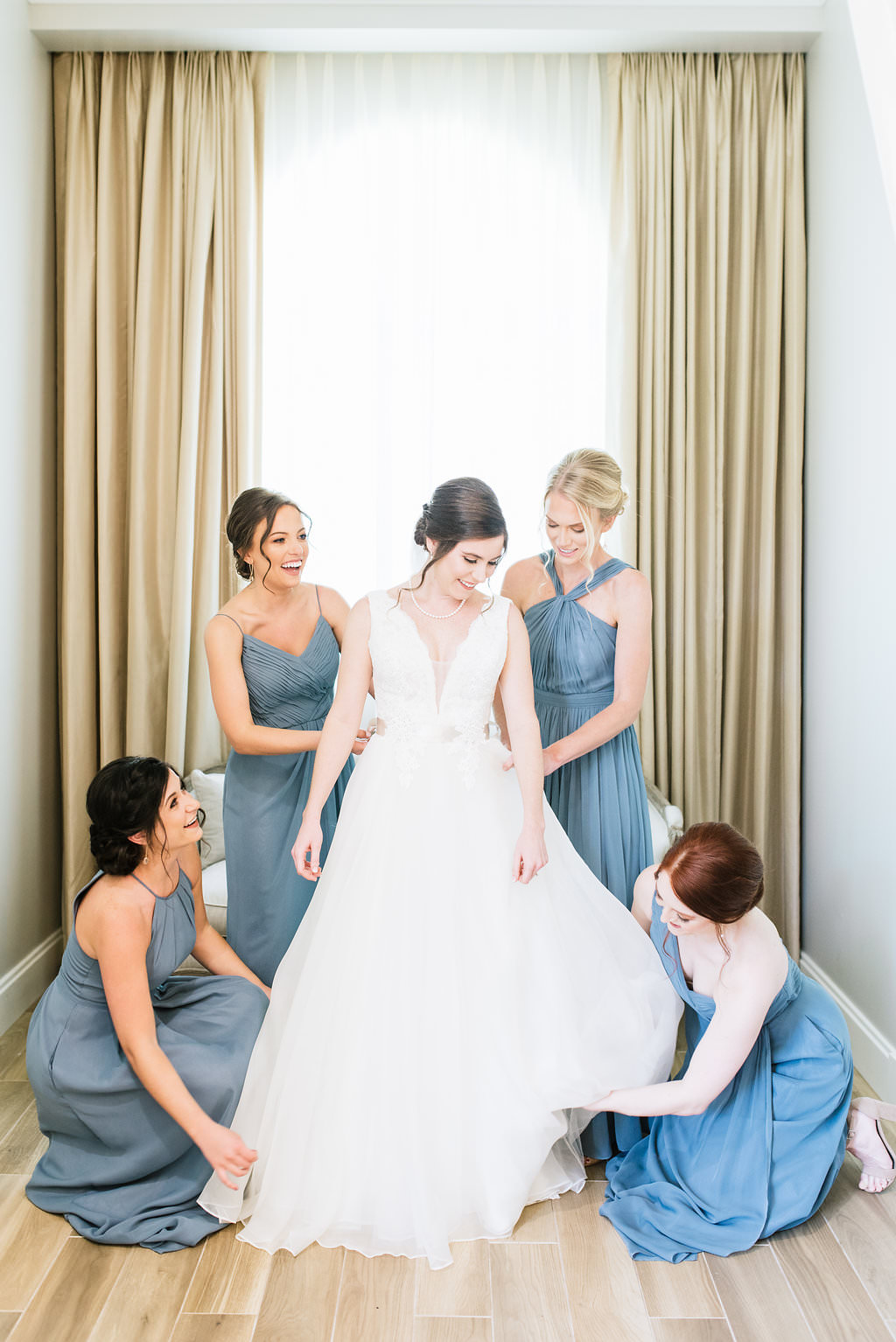 Florida Bride and Bridesmaids Getting Ready Wedding Portrait, Bridesmaids in Dusty Blue, Slate Blue Long Mismatched Style Dresses, Bride in Tank Top Strap Deep V-Neckline Ball Gown Wedding Dress with Satin Belt | Tampa Bay Hair and Makeup Artist Michele Renee the Studio