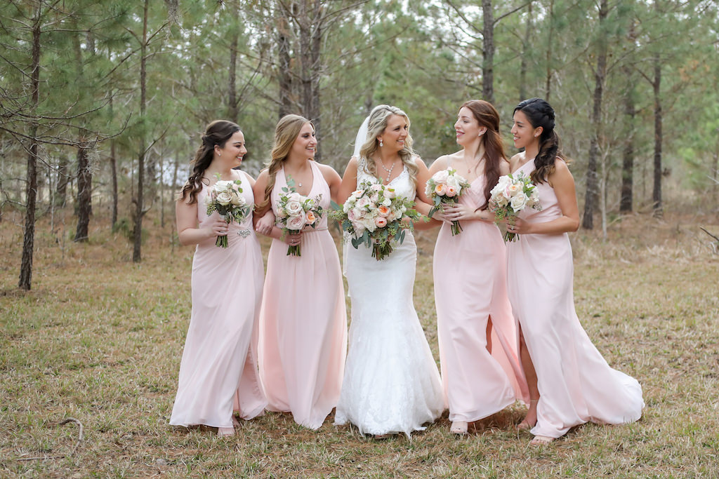 Florida Bride and Bridesmaids Outdoor Wedding Portrait, Bridesmaids in Blush Pink Long Mismatched Style Dresses, Bride in Lace V Neckline and Tank Top Strap Fit and Flare Wedding Dress with Blush Pink, Ivory and Greenery Floral Bouquet | Tampa Bay Wedding Photographer Lifelong Photography Studios | Tampa Bay Hair and Makeup Artist Femme Akoi