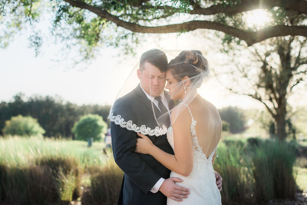 Tampa Bay Bride and Groom Intimate Creative Outdoor Wedding Portrait Under Veil | Wedding Dress Shop Truly Forever Bridal