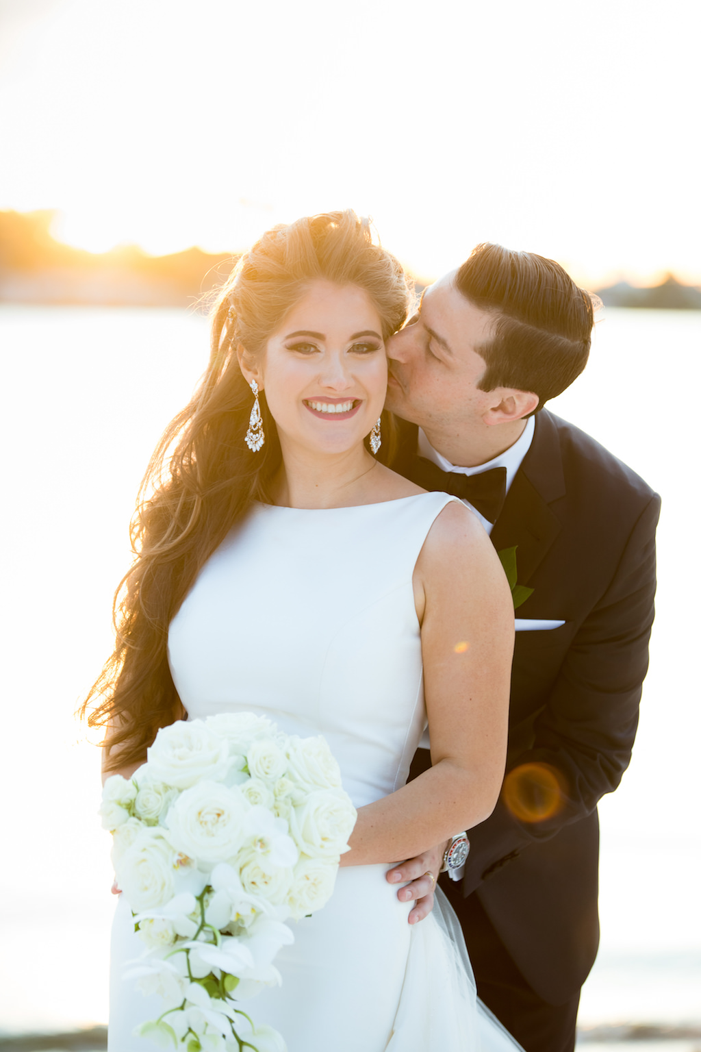 Tampa Bay Bride and Groom Sunset Wedding Portrait in White Halter Neckline Fitted Wedding Dress with White Rose and Orchid Floral Bouquet | Hair and Makeup Destiny and Light Hair and Makeup Group