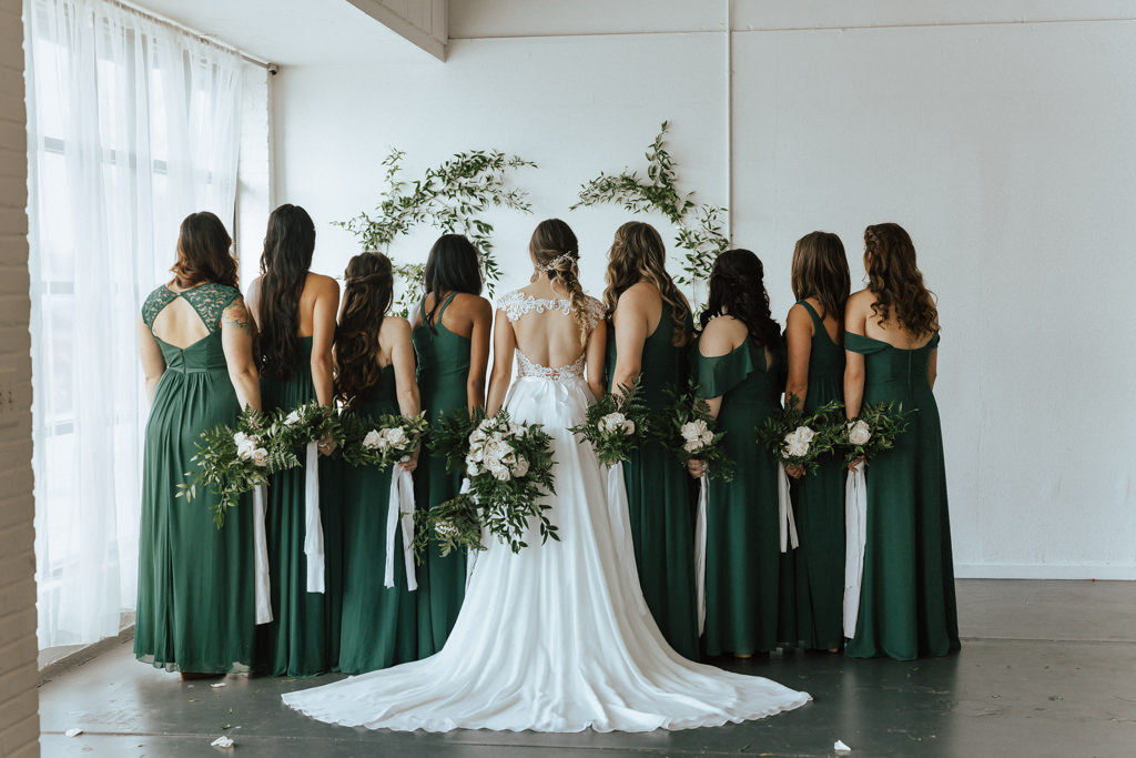 Florida Bride and Bridesmaids Wedding Portrait, Bridesmaids in Green Mismatched Style Dresses, Bride in Flowy Wedding Dress with Keyhole Back and Organic Ivory and Greenery Floral Bouquet | Lakeland Wedding Venue HAUS 820