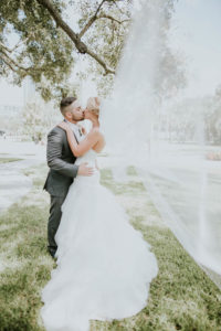 Creative Bride and Groom Veil Blowing in the Wind Outdoor Wedding Portrait