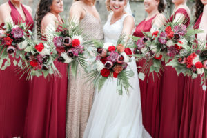 Bride and Bridesmaids Outdoor Wedding Portrait, Bridesmaids in Mismatched Style Red Long Dresses, Maid of Honor in Rhinestone and Champagne Dress Holding Tropical Orange, Red, Purple, Pink, White, Silver Dollar Eucalyptus and Greenery Floral Bouquets | Tampa Bay Wedding Photographer Lifelong Photography Studio