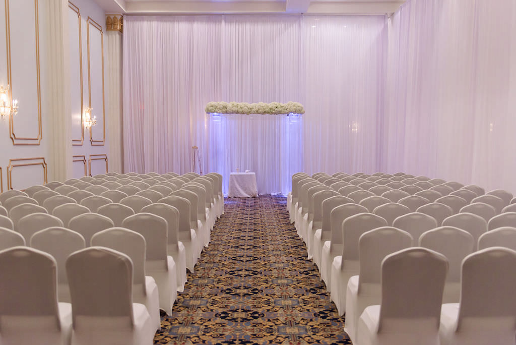 Modern Indoor Wedding Ceremony Decor, Chairs with White Covers, White Linen Drapery, Clear Lighted Acrylic Chuppa | Tampa Bay Wedding Planner Breezin Entertainment | Downtown Tampa Wedding Hotel Venue Floridian Palace Hotel
