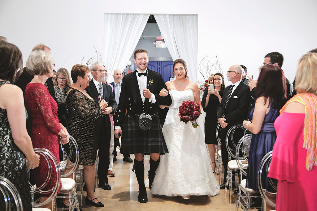 Florida Bride Entering Wedding Ceremony with Groomsmen in Black Dress Suit and Kilt, Bride in Strapless Sweetheart Lace and Rhinestone Belt Ballgown Wedding Dress with Dark Red, Burgundy Floral Bouquet | Wedding Planner Kelly Kennedy Weddings and Events