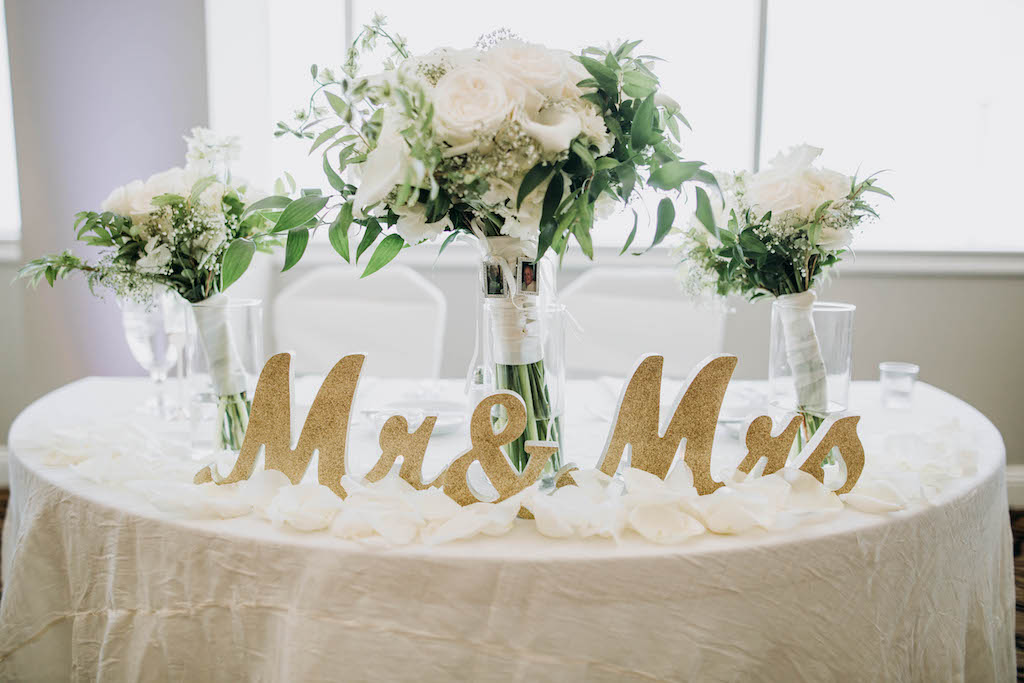 Traditional Classic Wedding Reception Decor, Sweetheart Table with Ivory Tablecloth, Gold Glitter Mr and Mrs Signs, White, Ivory and Greenery Floral Centerpieces