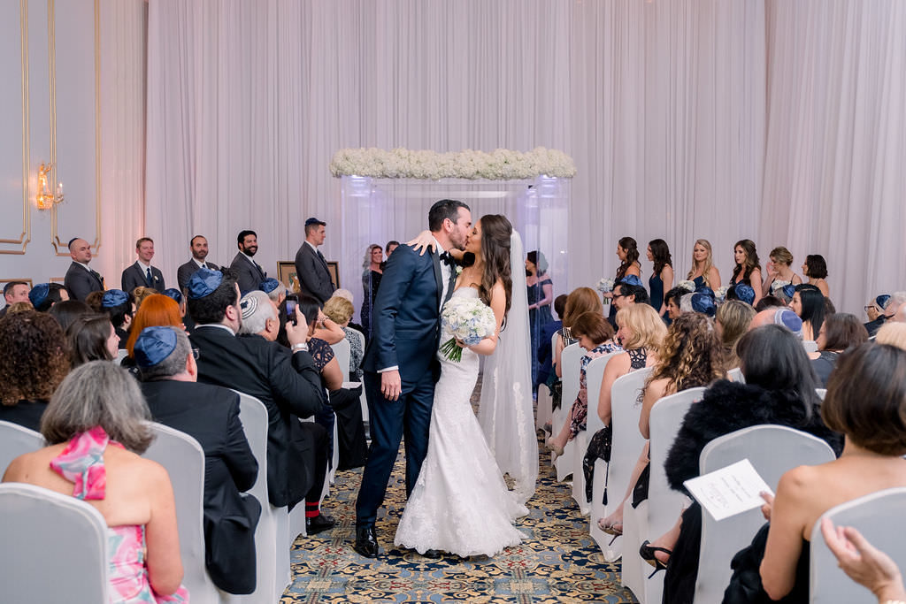 Florida Bride and Groom Wedding Ceremony Exit Wedding Portrait, Modern Wedding Decor Clear Lighted Acrylic Chuppa with White Flowers and White Linen Draping | Downtown Tampa Wedding Hotel Venue Floridian Palace Hotel | Tampa Bay Wedding Planner Breezin Entertainment