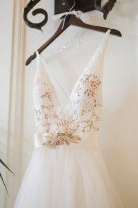 Lace Nude and White Deep V Neckline with Straps, Ivory Sash and Floral Rhinestone Brooch, Tulle and Illusion Skirt on Custom Wooden Hanger | Tampa Bay Wedding Photographer Lifelong Photography Studios