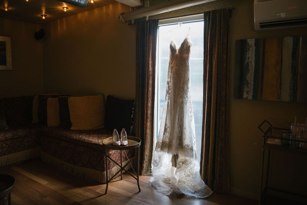 Lace wedding dress hanging in window