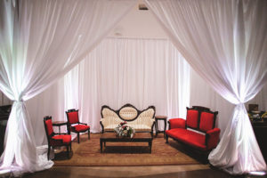 Modern Wedding Reception Decor, Ivory Tufted Loveseat, Red Velvet Seats and Loveseat, Wooden Coffee Table with Floral Arrangement, White Drapery | Tampa Bay Wedding Planner Kelly Kennedy Weddings and Events