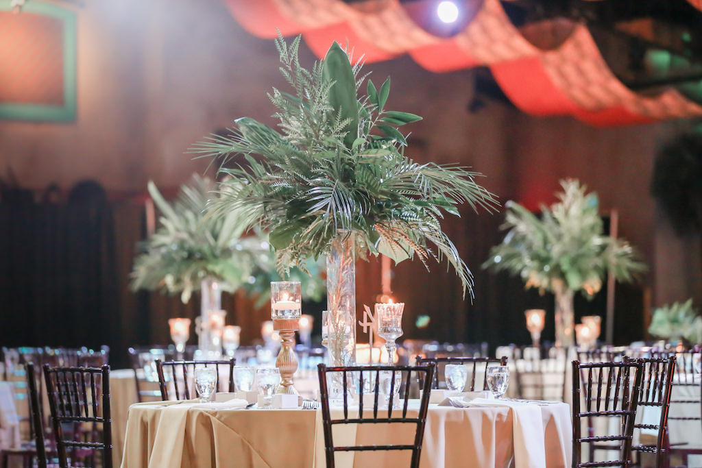 Tropical Inspired Wedding Reception Decor, Round and Long Tables with White Tablecloths, Wooden Chiavari Chairs, Tall Clear Glass Vases with Palm Tree Leaves Centerpieces, Gold Candlesticks with Floating Candles | Tampa Bay Wedding Photographer Lifelong Photography Studio | Tampa Unique Wedding Venue ZooTampa at Lowry Park