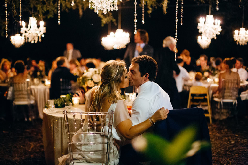 Boho Chic Bride and Groom Outdoor Garden Wedding Portrait Kissing, Ghost Acrylic Chiavari Chairs | Tampa Bay Wedding Planner NK Productions | Sarasota Wedding Venue Marie Selby Botanical Gardens