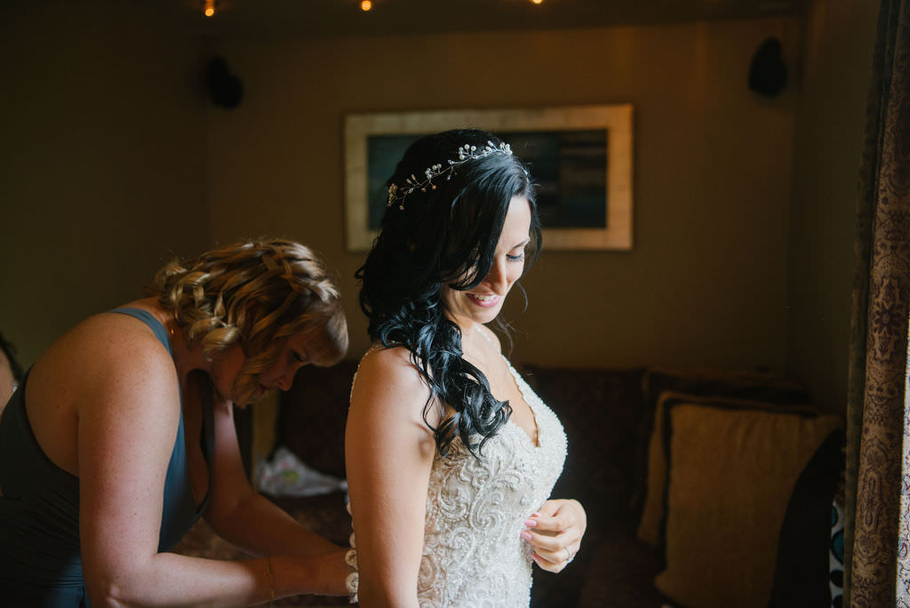 Bride in lace wedding dress getting dresses with crown hairpiece and flowing curls