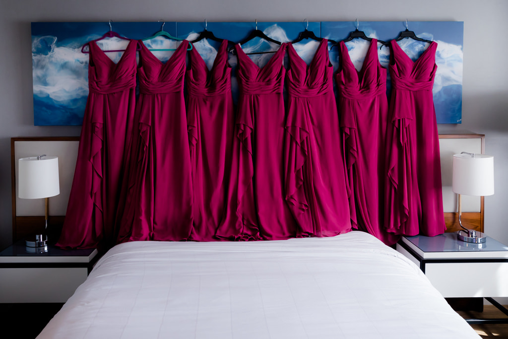 Magenta Red Matching Bridesmaids Dresses Hanging in Hotel Room |
