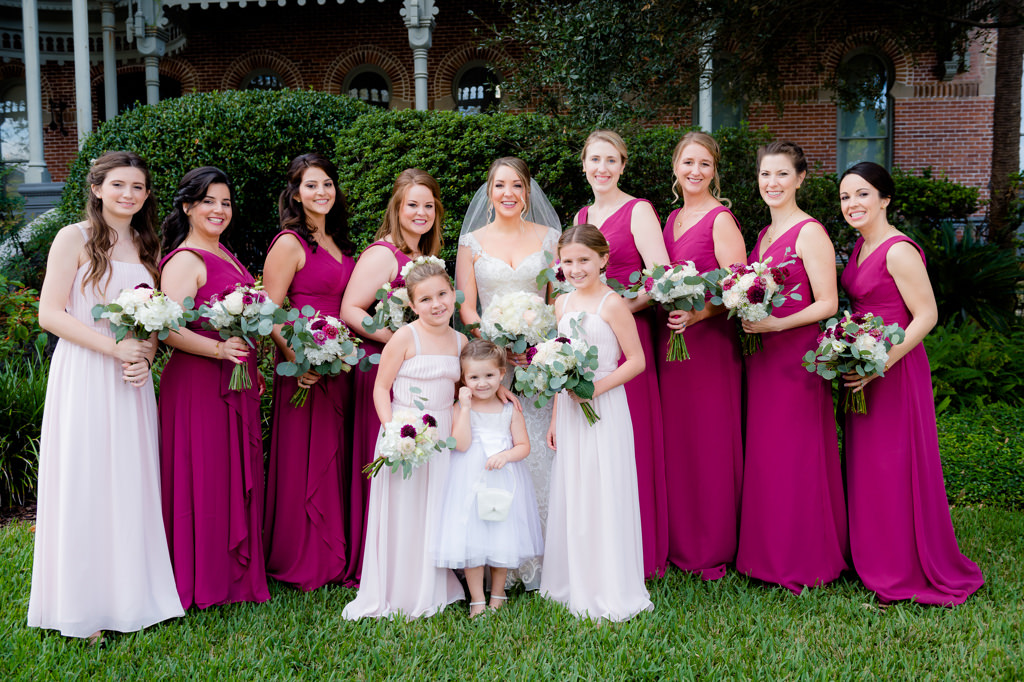 Florida Bride and Bridal Party Wedding Portrait, Bridesmaids in Matching Magenta Dresses, Flower Girls in Blush Pink Dresses with Ivory, Red, Greenery Floral Bouquets