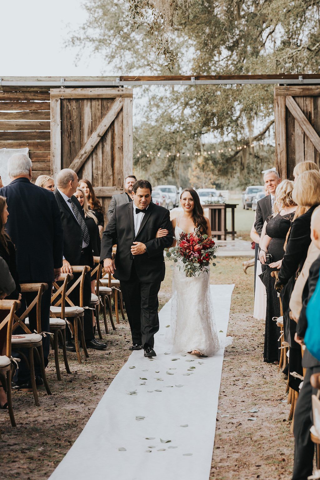 Bride and Father of the Bride Wedding Processional, Walking Down the Aisle, White Runner, Oversized Large Wooden Barn Doors, Red and Pink Floral Wedding Bouquet, Rustic Florida Farm Venue